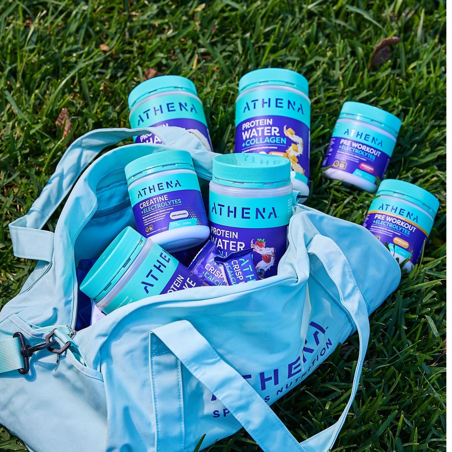 Athena supplement containers on a blue bag with grass in the background